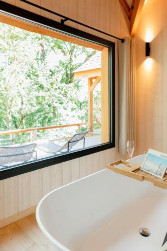 a bath tub in a room with a large window at Dolce et Cabane in Bérat