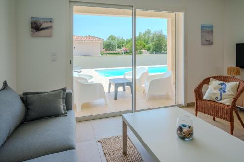 - un salon avec un canapé, une table et une piscine dans l'établissement Villa Clara piscine chauffée, à Prunelli-di-Fiumorbo