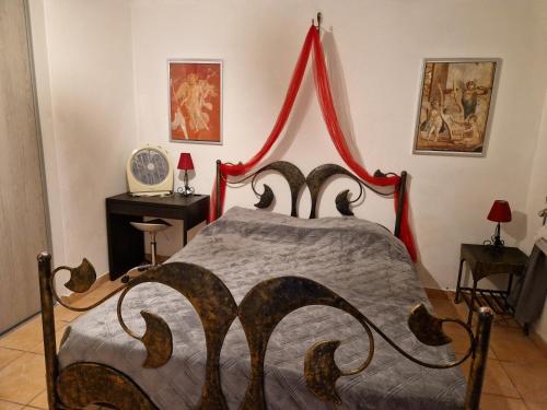 - une chambre avec un lit à baldaquin rouge dans l'établissement Villa Sambracitaine, aux Issambres