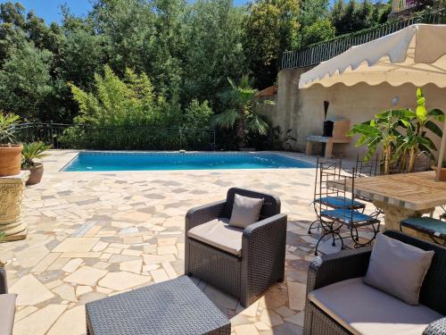 un patio avec des chaises et une piscine dans l'établissement Villa Sambracitaine, aux Issambres