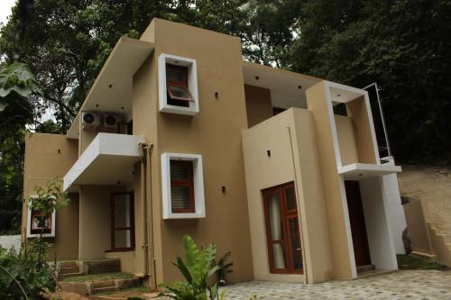 a building with white windows on the side of it at Kandy Lotus Chalet in Kandy