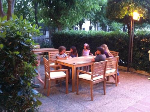 a group of children sitting around a wooden table at Hotel Viking in Rimini