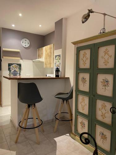une cuisine avec deux tabourets de bar et un comptoir dans l'établissement Suite Deloye FSHH, à Nice