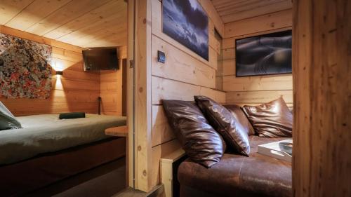 a room with a couch and a bed in a cabin at Lodge plein pied avec jardin à 10min de Chamonix in Servoz