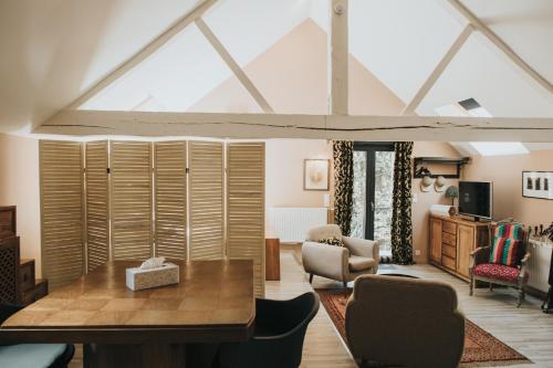 a living room with a wooden table and chairs at LOGIS HÔTEL-RESTAURANT - Le Moulin d'Artres in Artres