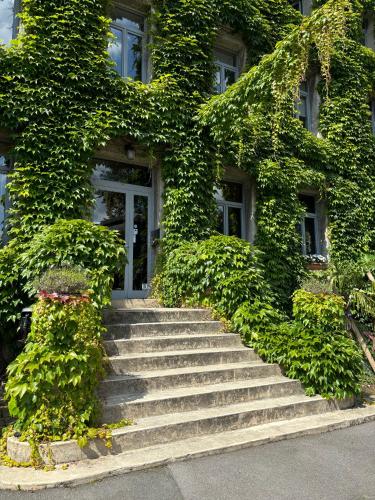 a building with stairs in front of a building at LOGIS HÔTEL-RESTAURANT - Le Moulin d'Artres in Artres