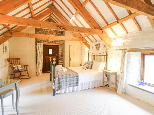 a bedroom with a bed in a room with wooden ceilings at Stable Cottage in Newport Pembrokeshire