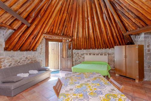 a room with a couch and a bed in a cabin at B&B Pettirosso Garden in San Teodoro
