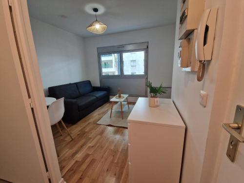 un salon avec un canapé et une table dans l'établissement Studio cosy, à Lyon