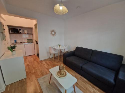 un salon avec un canapé noir et une table dans l'établissement Studio cosy, à Lyon