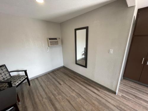 an empty room with a chair and a mirror at Sequoia Motel in Fresno
