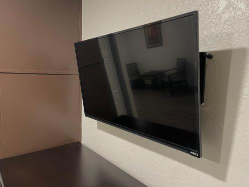 a flat screen tv hanging on a wall at Sequoia Motel in Fresno