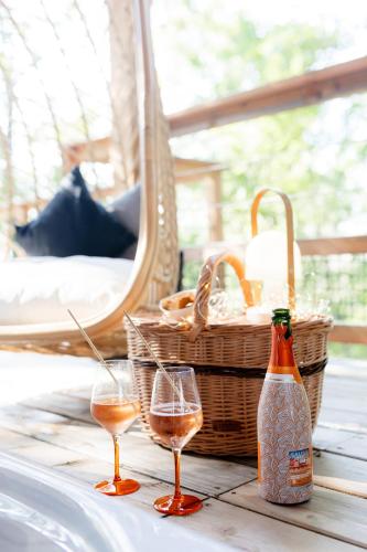 a table with two glasses of wine and a basket at Dolce et Cabane in Bérat