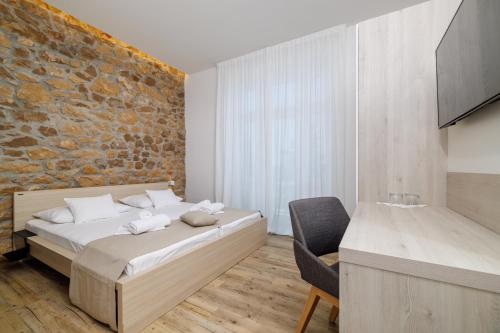 Un dormitorio con una cama y una pared de ladrillo. en VILLA ERIKA, en Crikvenica
