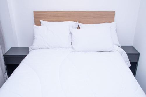a bed with white sheets and pillows at ST Studios Vila Mariana by Housi in Sao Paulo