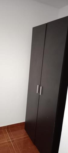 a black cabinet in the corner of a room at En casa baño compartido in Chía