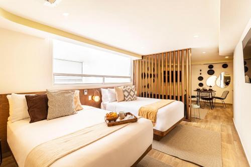 a hotel room with two beds and a table at Grand Chapultepec Residencial in Mexico City