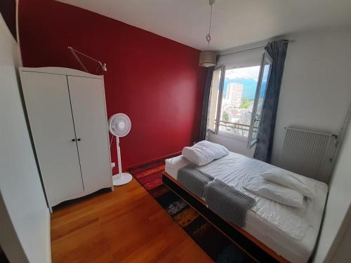 une petite chambre avec un lit et une fenêtre dans l'établissement R'Apparts T2 Cosy et Vintage, à Grenoble