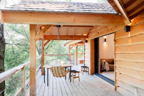a porch of a cabin with a table and chairs at Dolce et Cabane in Bérat
