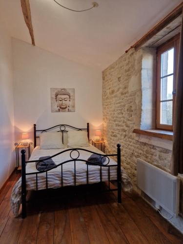 une chambre avec un lit et un mur de briques dans l'établissement Le Bois Fleuri : Ensemble de 3 gîtes avec piscine pour 18 personnes, à Saint-Crépin