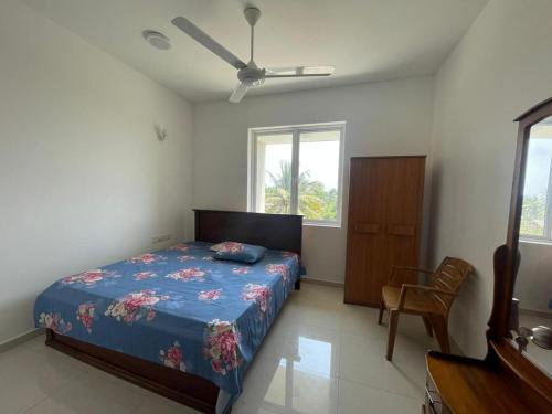 Un dormitorio con una cama y una silla dentro. en Beachfront Apartment, en Wattala