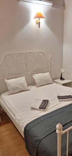a bedroom with a bed with white sheets and a lamp at Kuća za odmor Emanuela in Vodice