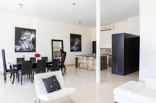 a white living room with a table and chairs at 3BR Downtown Condo with Amazing Views in Cabo San Lucas