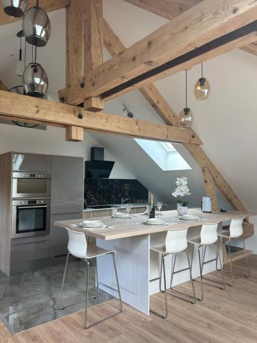 ChavanodAppartement Annecy 74的厨房设有白色的台椅和大岛