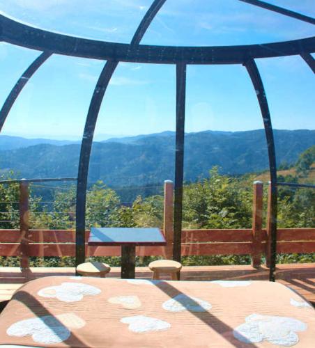 a table and chairs in a gazebo with a view at Nuits D'y Cîmes : Nuit Insolite Bulle, SPA in Jaunac