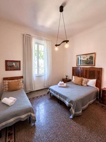 a bedroom with two beds and a window at La Casa di Eli Appartamenti in Pisa