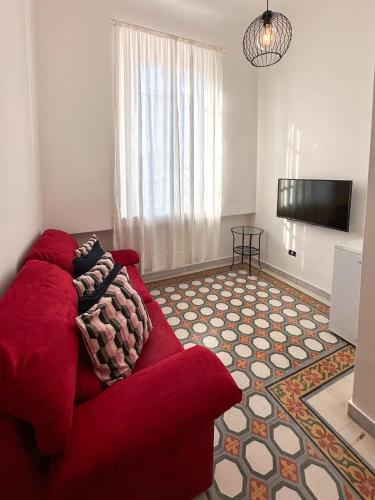 a living room with a red couch and a flat screen tv at La Casa di Eli Appartamenti in Pisa