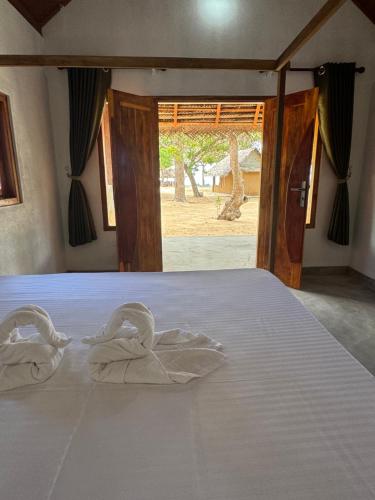 a bed with two swan towels on it at Peanut Farm Surf and Wild Resort - Arugambay in Arugam Bay