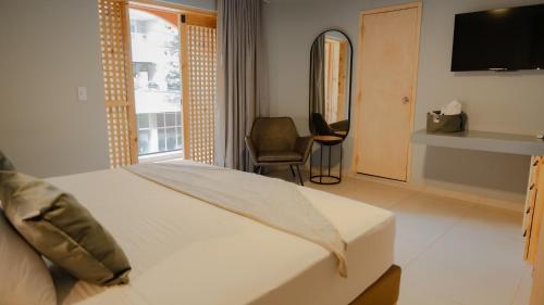 a hotel room with a bed and a television at Leviu by Bernalo Hotels in Medellín