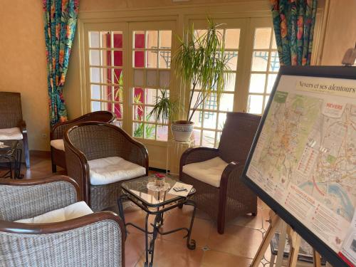 a room with chairs and a map and a table at The Originals Boutique, Hôtel Clos Sainte Marie, Nevers in Nevers