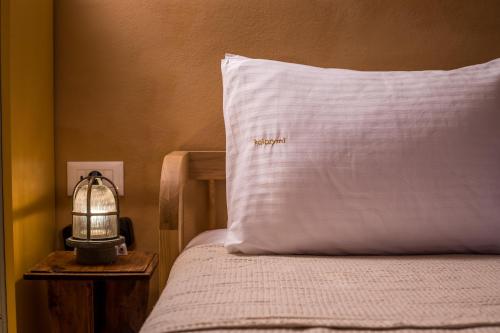 a bed with a pillow with the word spanish on it at kalosymi studio, Symi in Symi