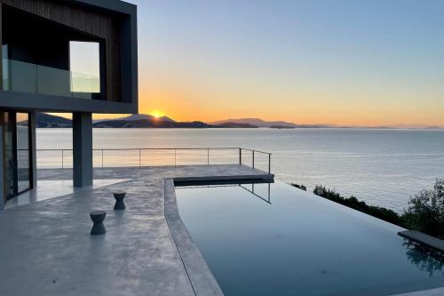 シヴォタにあるVILLA ODISSOS - Private Paradise with 2 infinity pools & Sea accessの日没時の海の景色を望む家