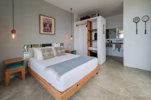 a bedroom with a large white bed in a room at Tropicalito Villa on the Beach in Tulum