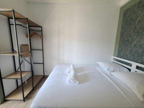 - un lit blanc dans une chambre avec une étagère dans l'établissement Havre Lumineux avec Climatisation et Terrasse, à Montpellier