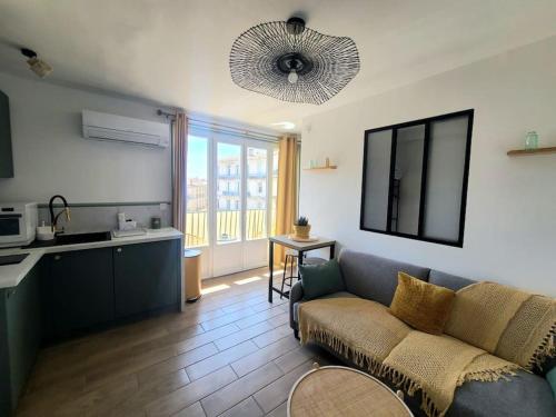 un salon avec un canapé et une cuisine dans l'établissement Havre Lumineux avec Climatisation et Terrasse, à Montpellier