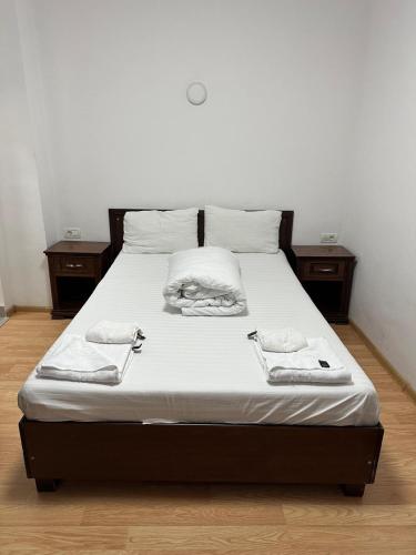 a bed with white sheets and two towels on it at Pensiunea Balea in Cîmpeni