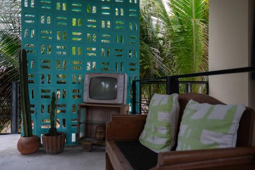 a living room with a couch and a tv at Tropicalito Villa on the Beach in Tulum