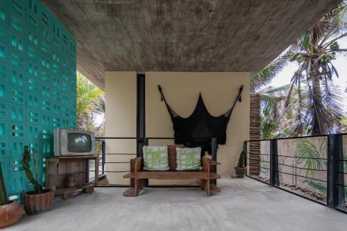a living room with a couch and a tv at Tropicalito Villa on the Beach in Tulum