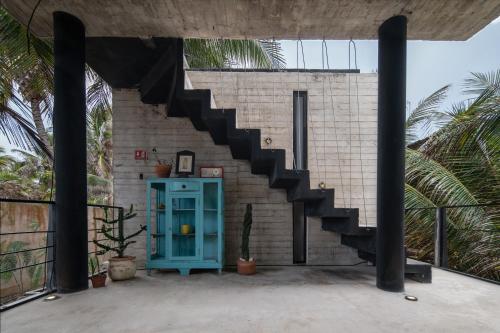 a house with a staircase on the side of it at Tropicalito Villa on the Beach in Tulum
