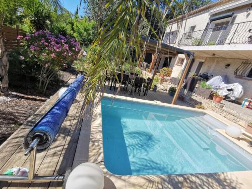 - une piscine avec un tuyau bleu à côté d'une maison dans l'établissement Bas de villa avec jardin, piscine et jacuzzi, à La Seyne-sur-Mer