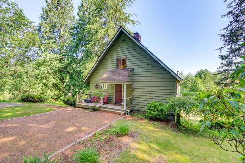 a green house with a porch and a patio at Langley Forest Cabin with Grill Less Than 2 Mi to Downtown! in Langley