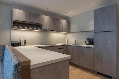 a large kitchen with stainless steel appliances and a counter at Appartements zum Strossna in Mayrhofen