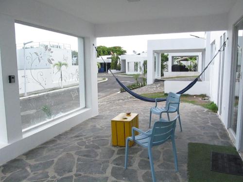 a patio with two chairs and a table and some windows at ADVENTURE House in Nancito
