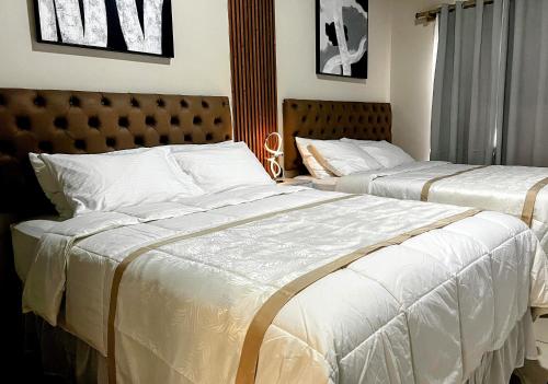 two beds in a hotel room with white sheets at GyV Executive in Tegucigalpa