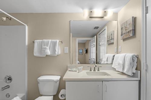 a white bathroom with a sink and a toilet at Tradewinds 307 in Orange Beach
