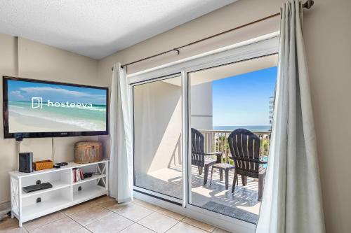 a room with a sliding glass door with a view of the ocean at Tradewinds 307 in Orange Beach